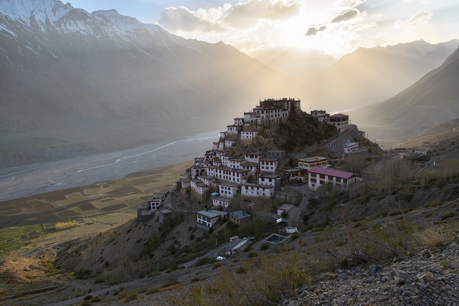 Key Monastery stacked on its conical hill above the braided Spiti river at golden hour