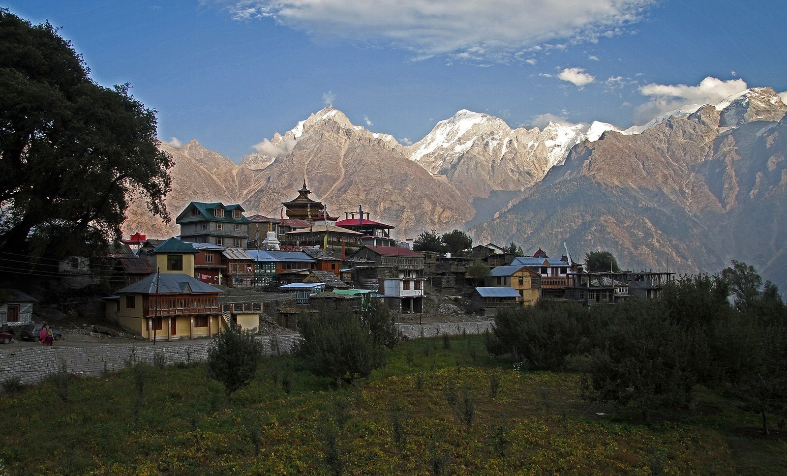 Kalpa village in Kinnaur with traditional houses and a pagoda temple in front of the snow-streaked Kinner Kailash range in clear autumn light