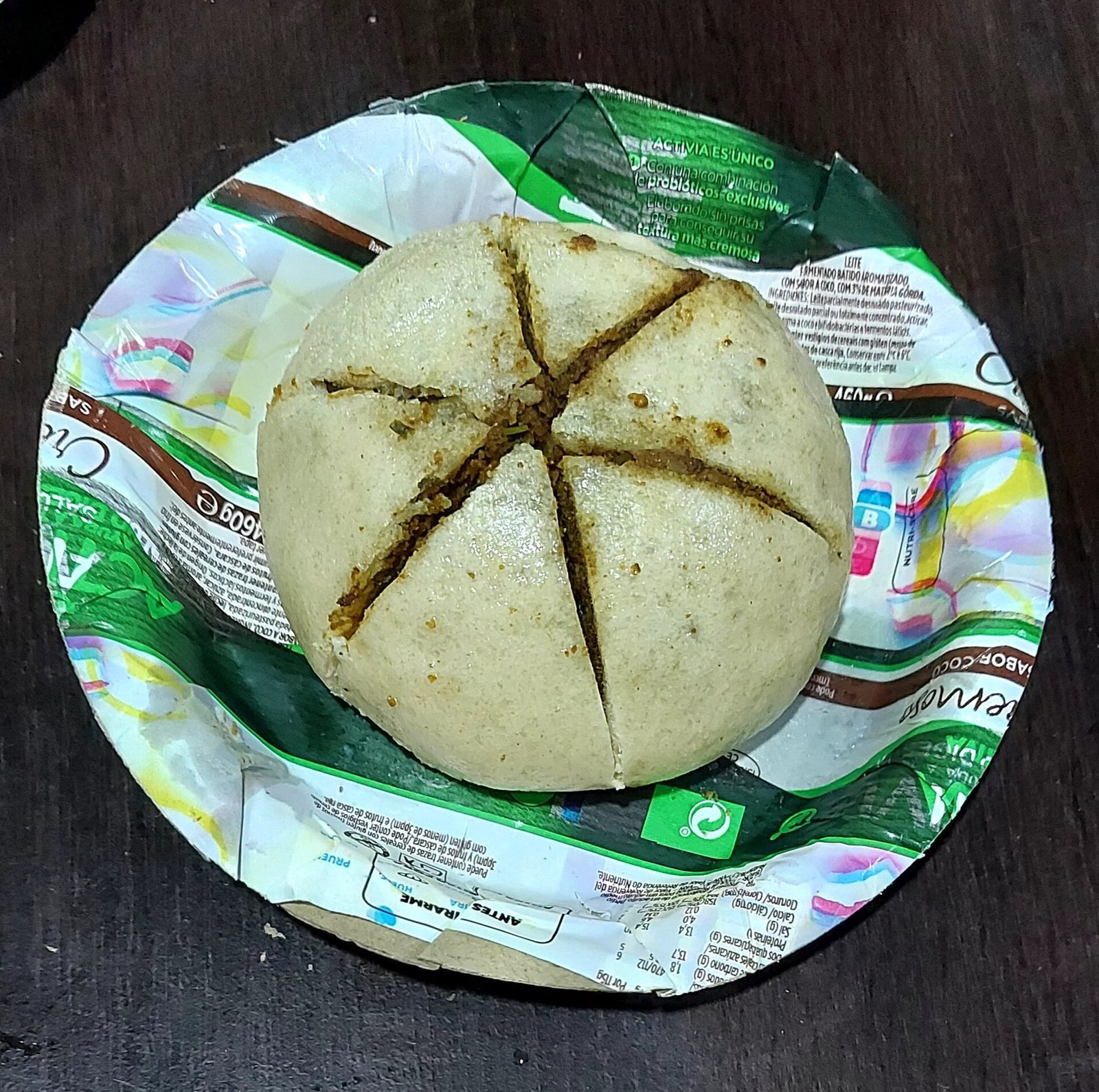 A steamed siddu cut into wedges on a leaf bowl, Himachali stuffed bread served with ghee